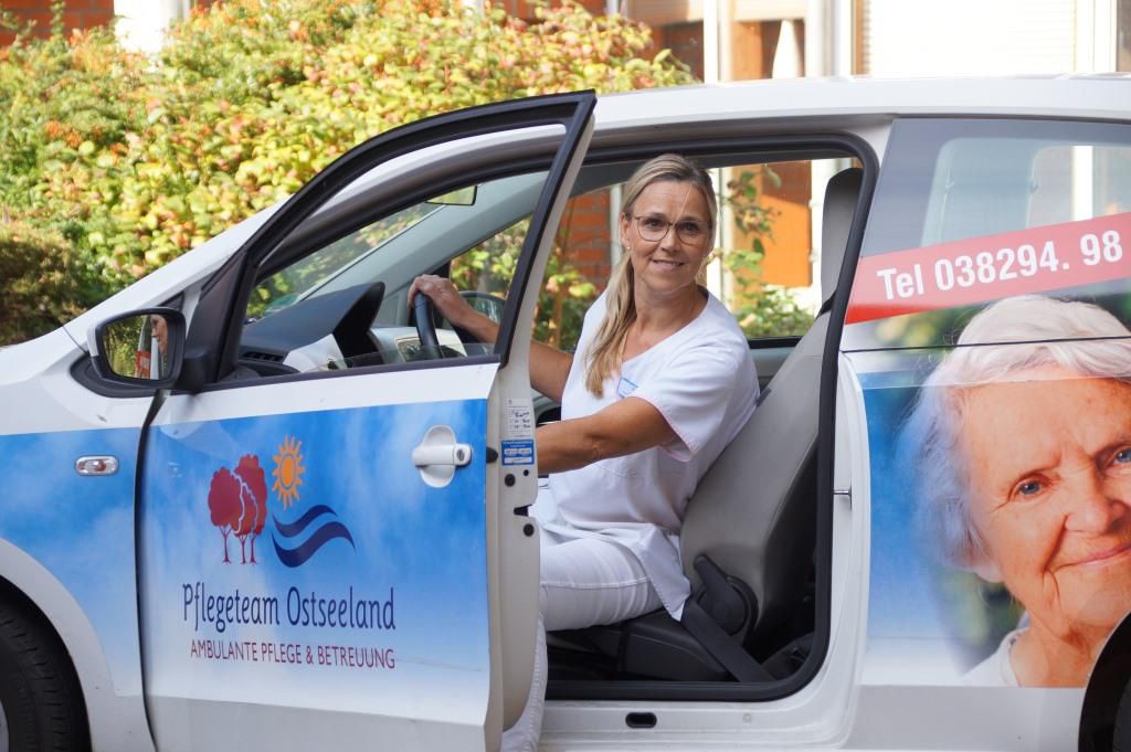 Mitarbeiterin steigt aus dem Auto aus